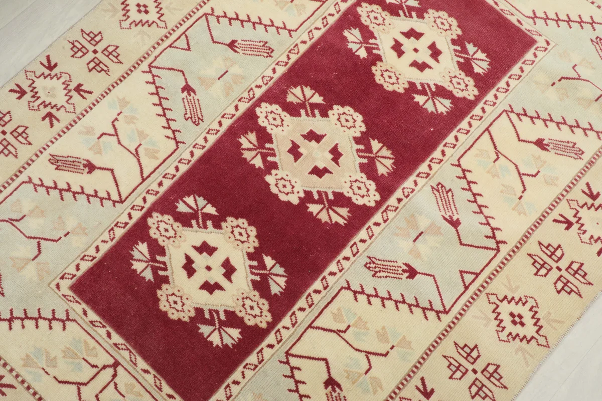 Overhead detail of the Rose Geometric Anatolian Rug's central rose panel with cream geometric motifs.