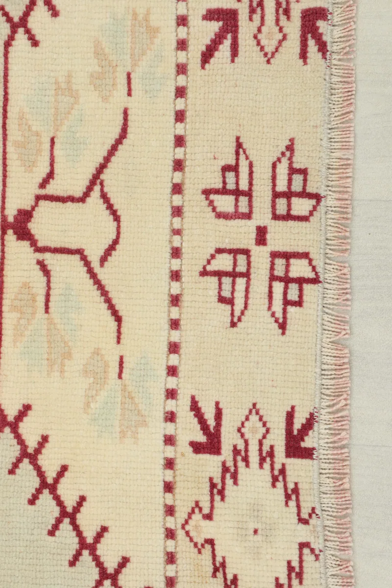 Detail of the Rose Geometric Anatolian Rug's edge, showing the intricate rose tribal patterns and fringe.