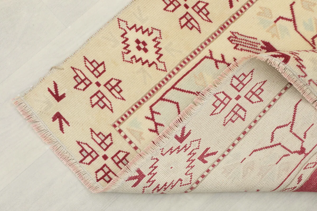 Rose Geometric Anatolian Rug folded back to reveal the cotton foundation and hand-knotted construction.