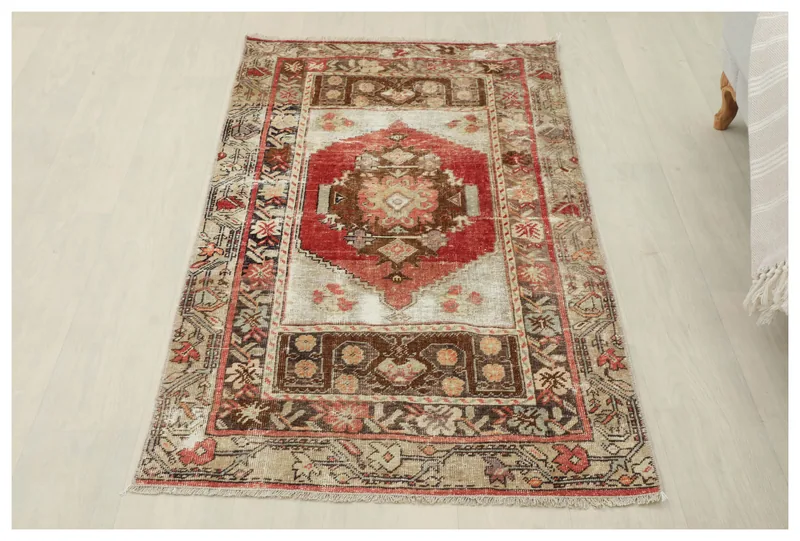 Full top view of the 2'8" x 5'0" vintage Anatolian rug with red medallion and brown geometric patterns