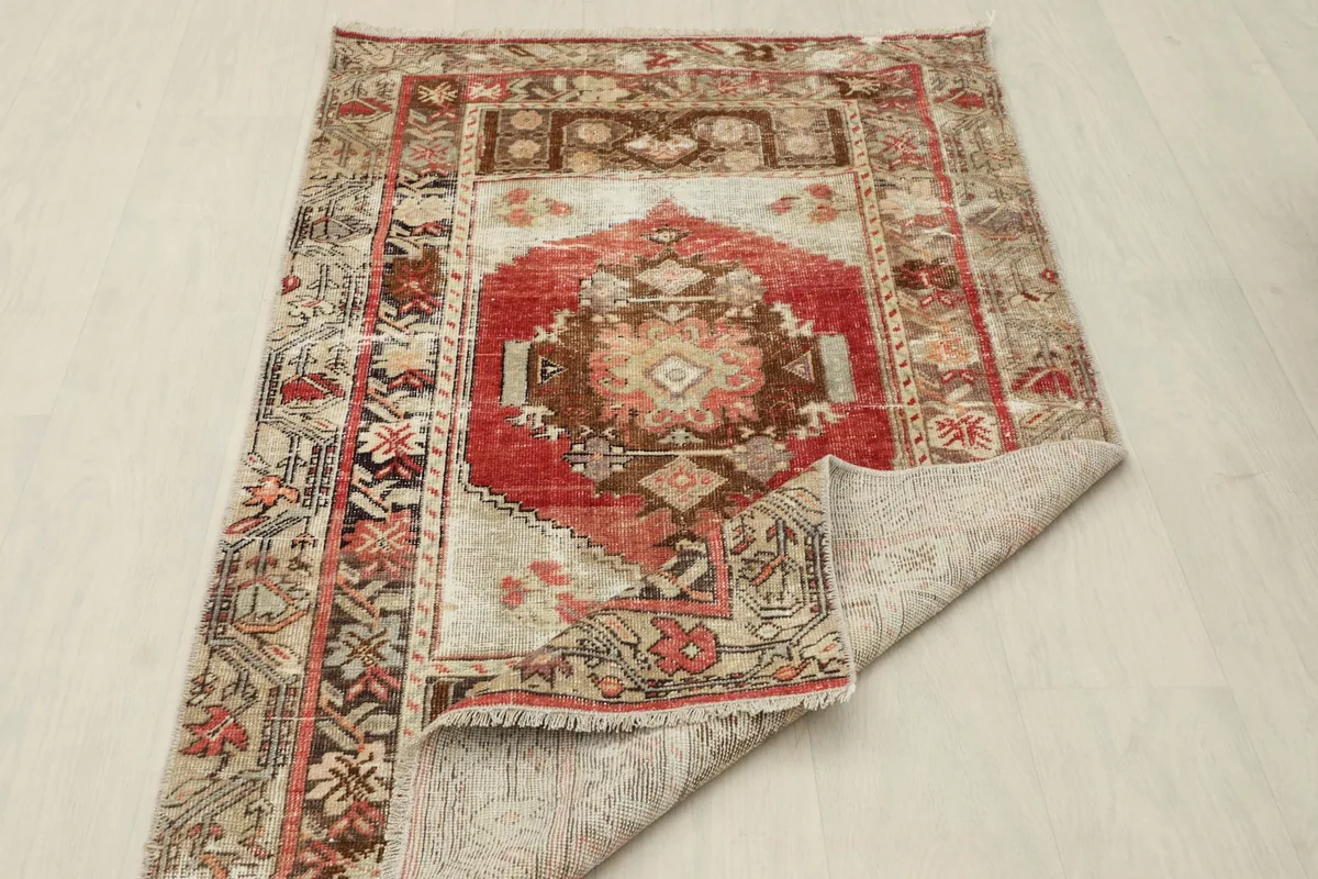 Rug partially folded back to show the cotton foundation and density of the weave