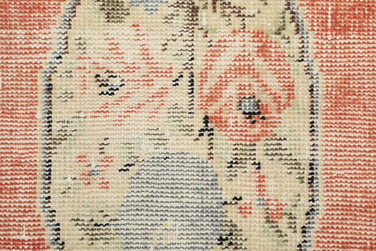Macro shot of the rug's low wool pile, revealing the hand-knotted texture and color variations