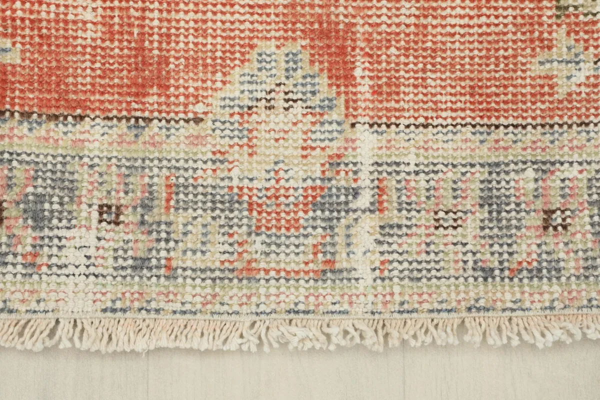 Close-up of the rug's short, natural cotton fringe and the distressed blue border