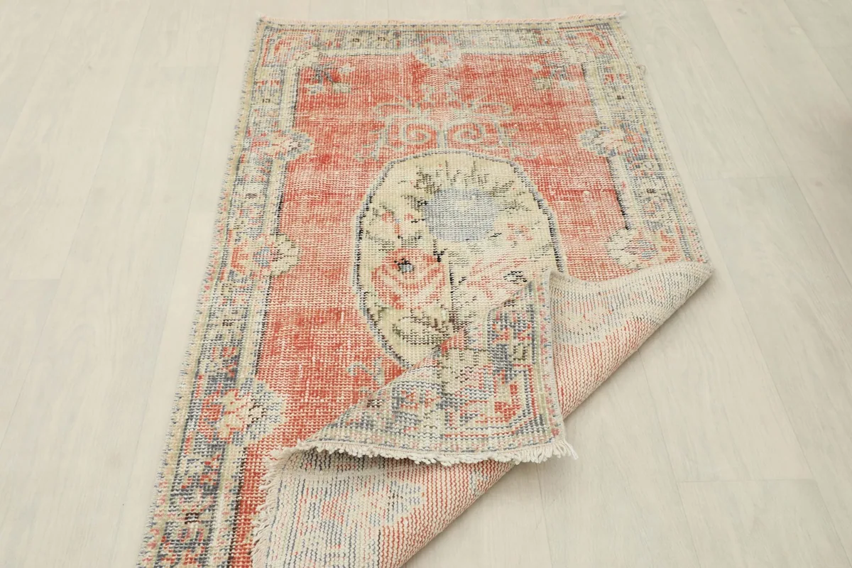 Rug partially folded, illustrating its flexibility and the woven texture of the backing