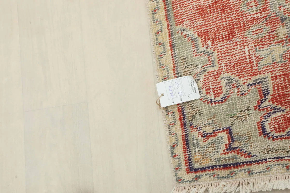 Overhead view of the rug with a measurement tag, indicating its size and vintage condition.