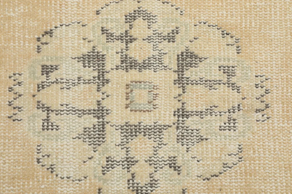 Very close-up showing the intricate knotting and texture of a gray medallion