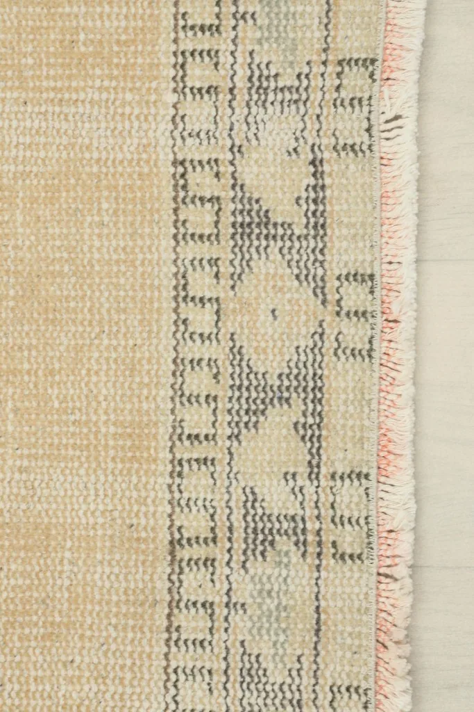 Close-up of the gray geometric border design and the short, natural fringe of the runner