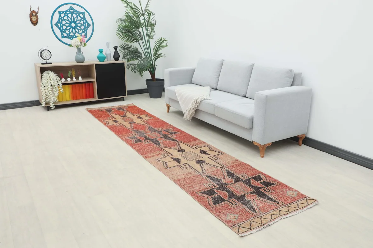 Long view of the vintage runner rug placed in a modern living space with a light sofa and decor.