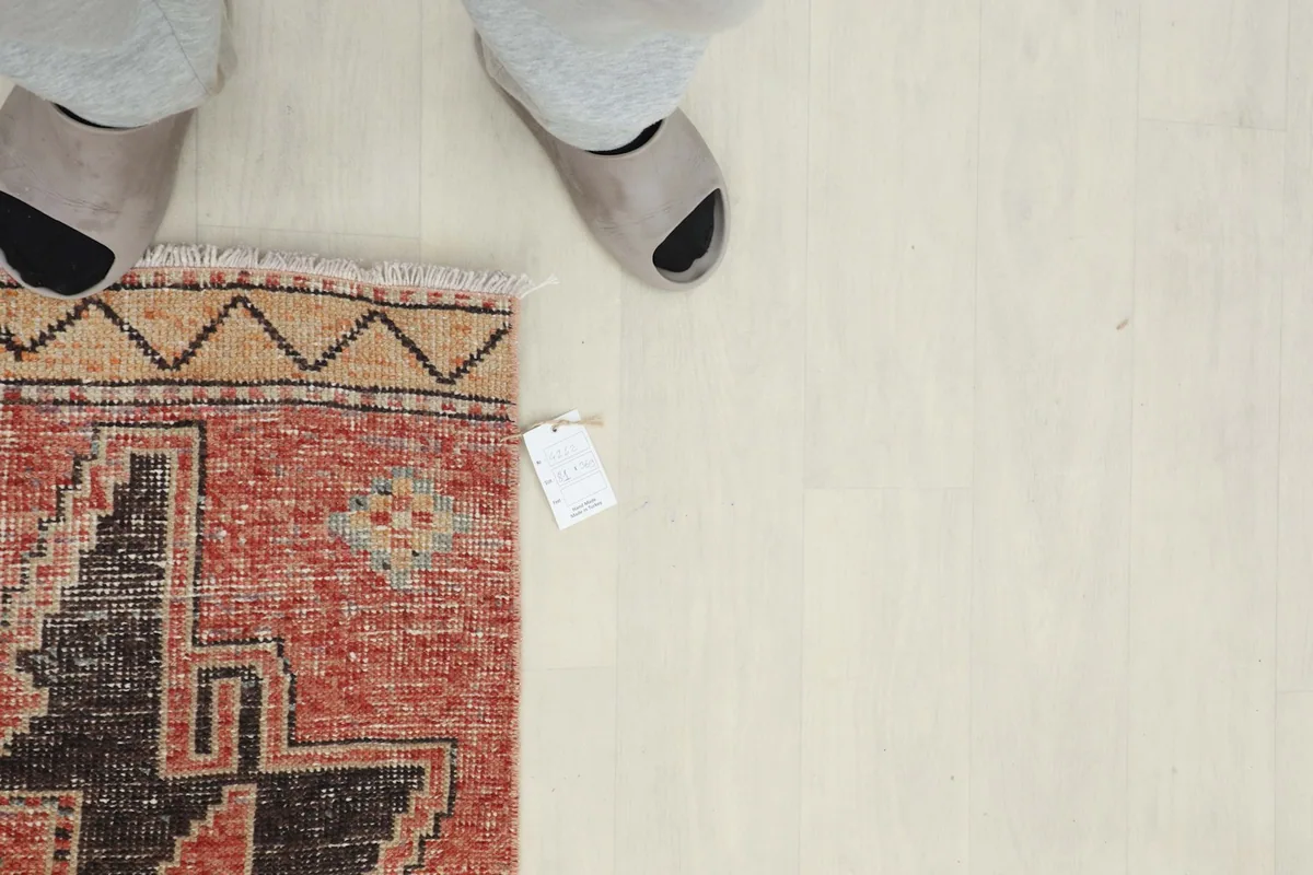 Overhead perspective of a section of the rug with feet nearby, showing scale and the texture.