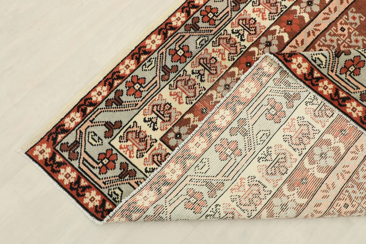 Folded corner of the rug, showing the back and the density of the hand-knotted weave.