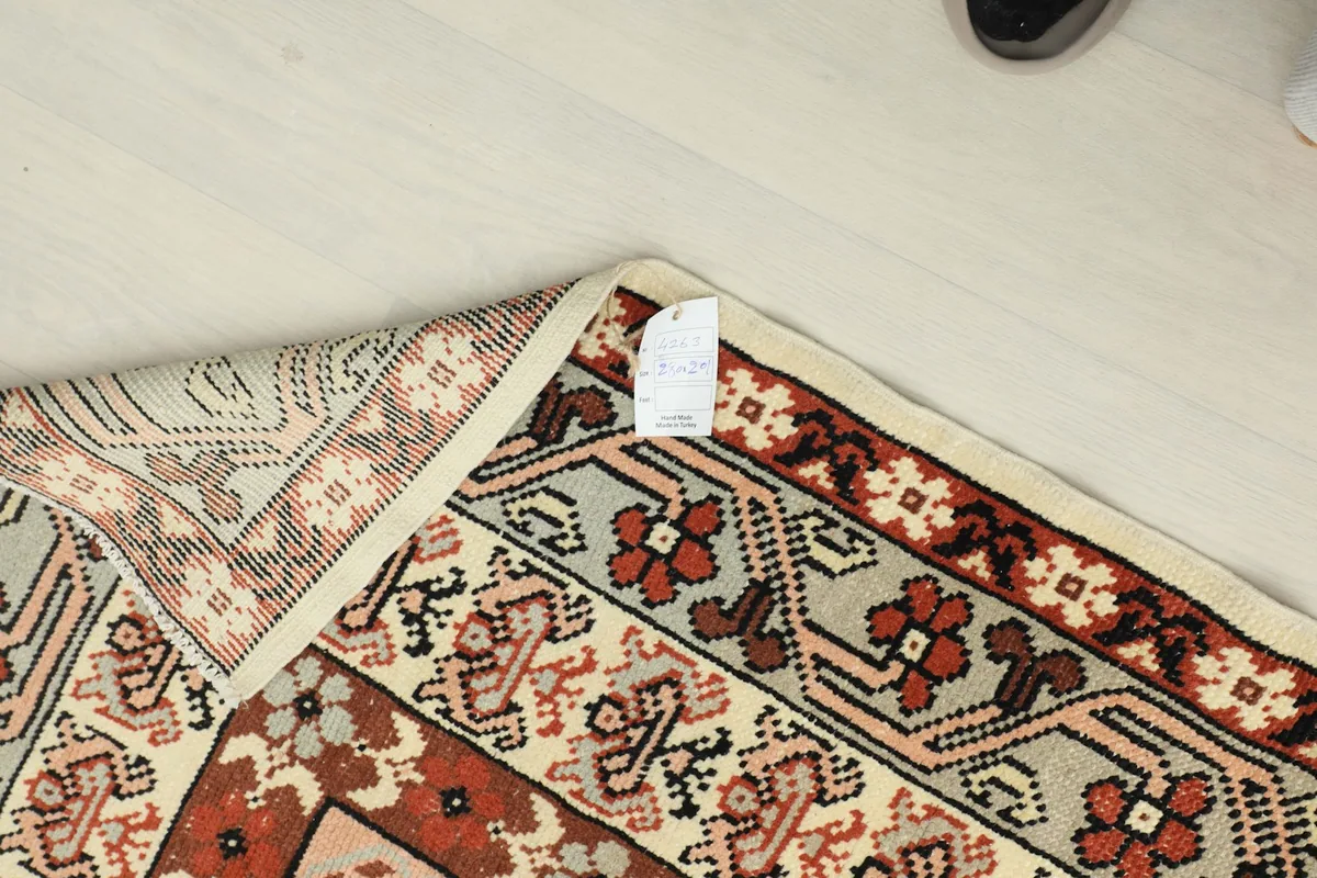 Corner of the rug with a label, indicating its origin and material.