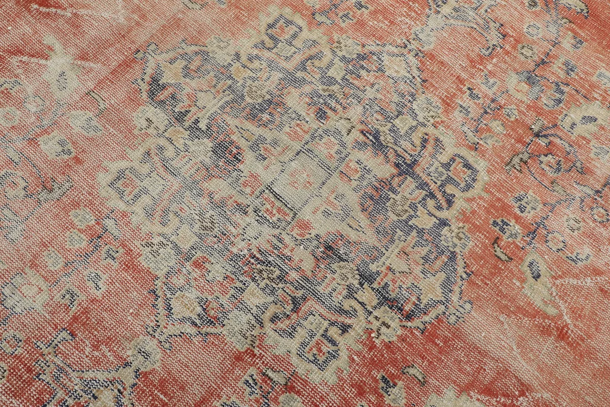 Detailed view of the central navy and cream medallion motif with surrounding rust field.