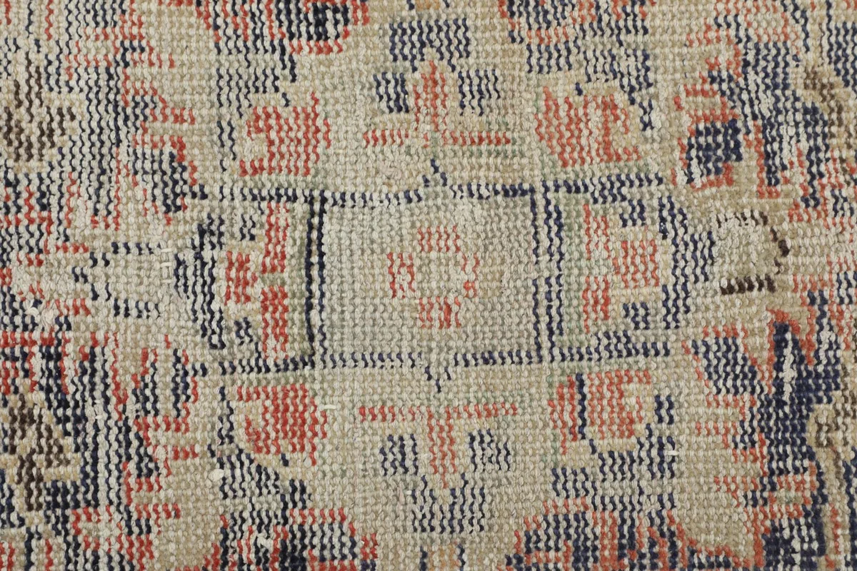 Close-up showing the low pile texture and hand-knotted wool construction of the vintage rug.