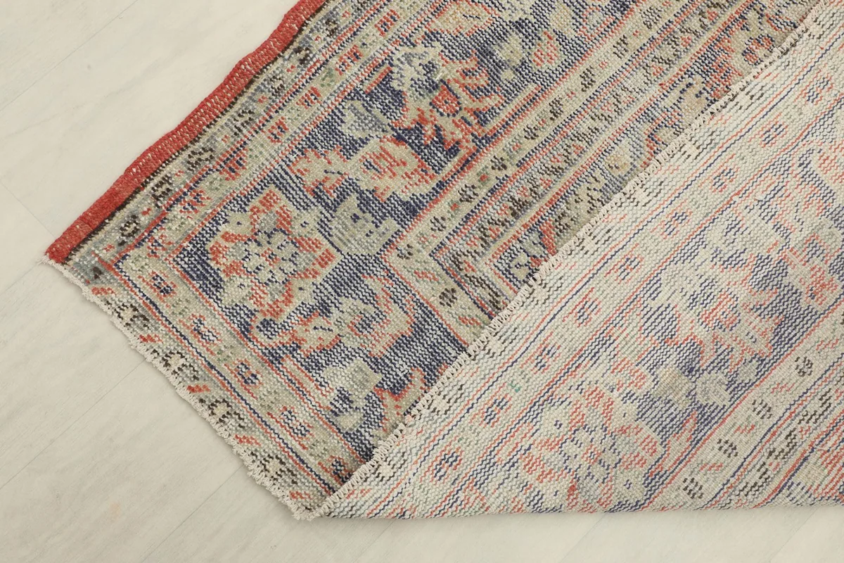 View of the back of the vintage hand-knotted rug, revealing its cotton foundation and knotting.