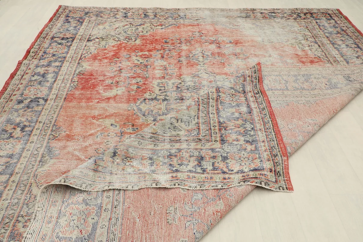 A section of the rug folded back, showing both the top pile and the reverse side.