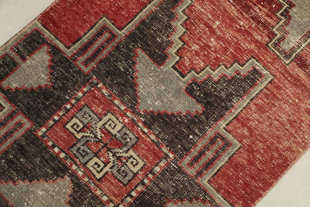 Detailed view of the central charcoal and gray geometric medallion with red accents