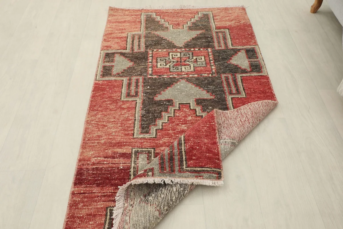 View of the rug with one corner folded back, revealing the reverse side and pile texture