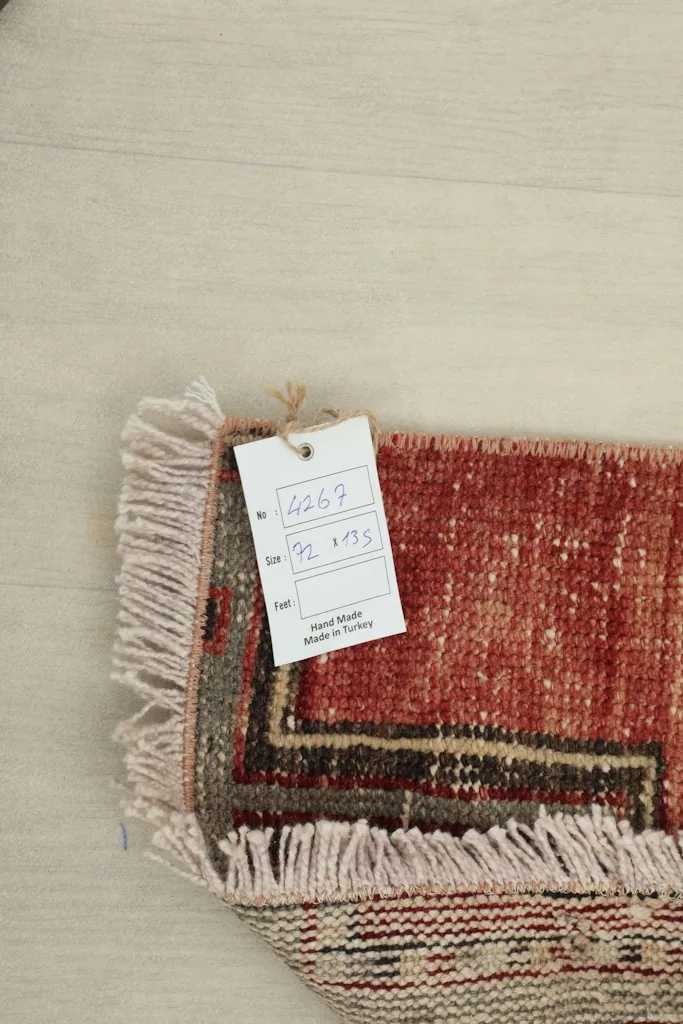 Overhead view of the rug's corner with a tag displaying product information and dimensions
