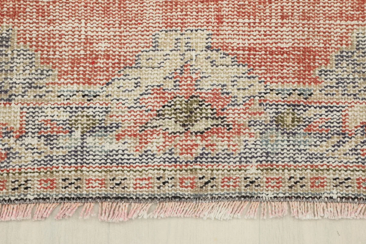 Detailed view of the rug's border and fringe, showing the hand-knotted texture
