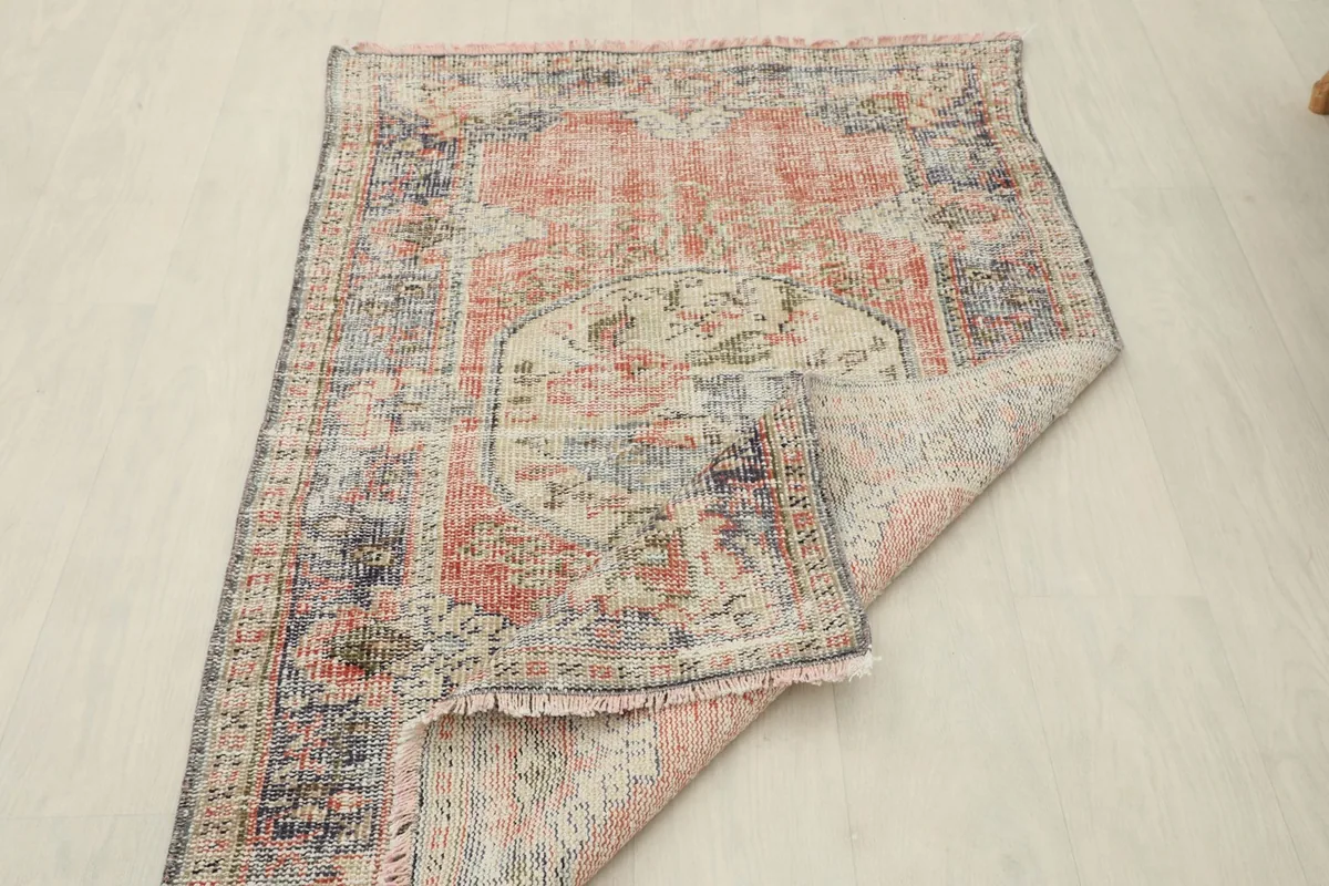 Rug partially folded, revealing the reverse side and the texture of the wool pile