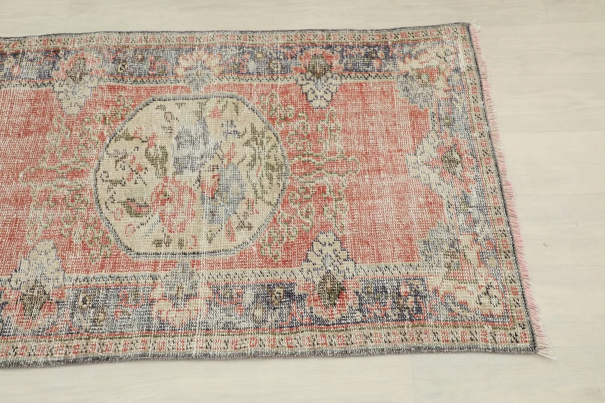 Close overhead view of the rug, showing the rose field and navy border details