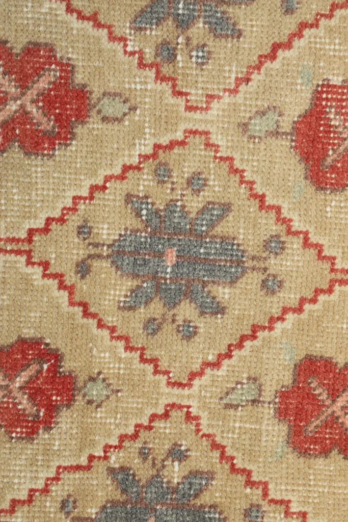 Macro detail of the hand-knotted wool pile, showing individual knots and color variations.