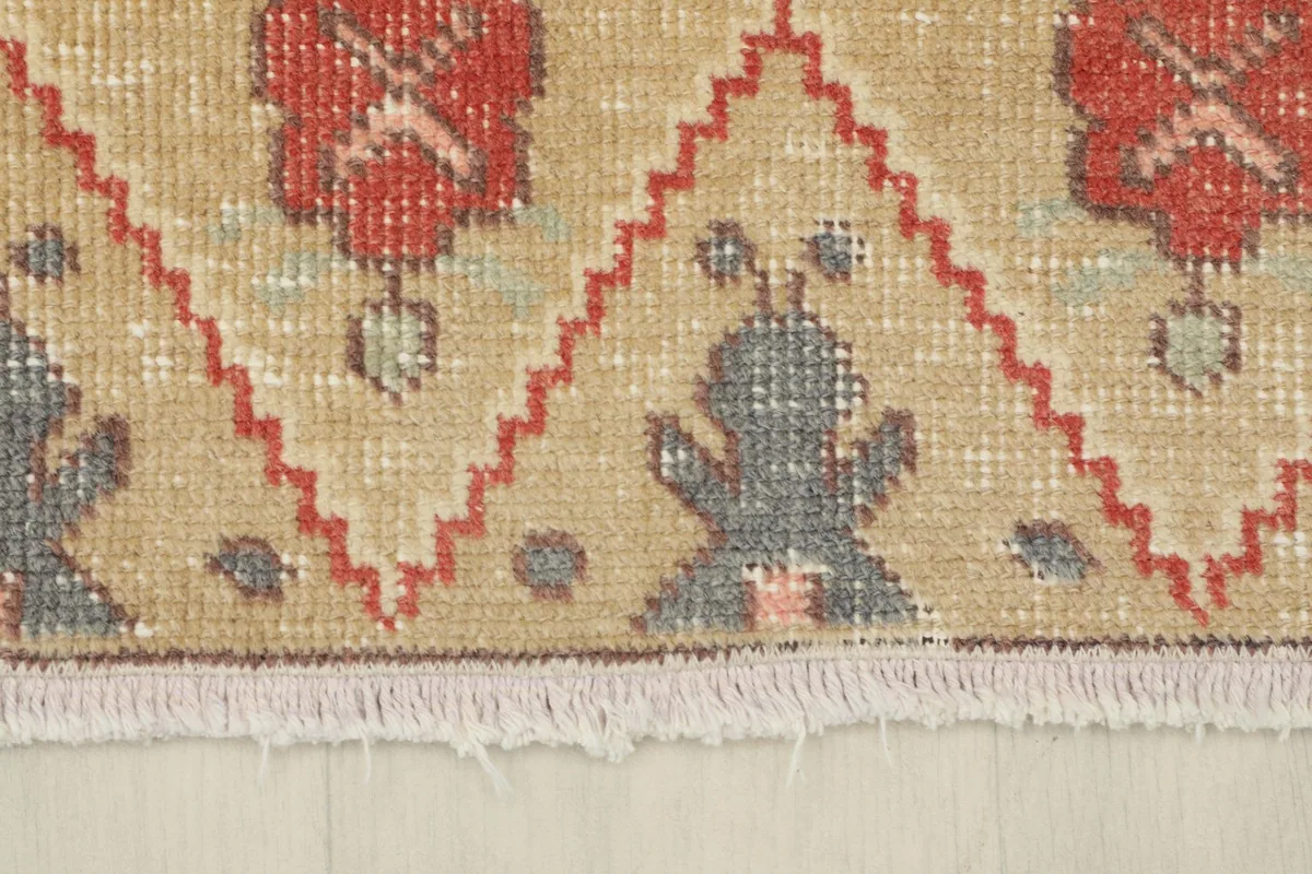 Close-up of the rug's short, natural fringe and the edge of the woven pattern.