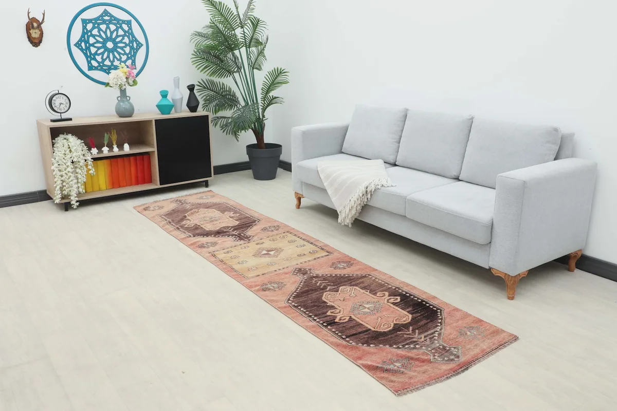 Runner rug displayed in a living room setting next to a gray sofa and wooden cabinet.