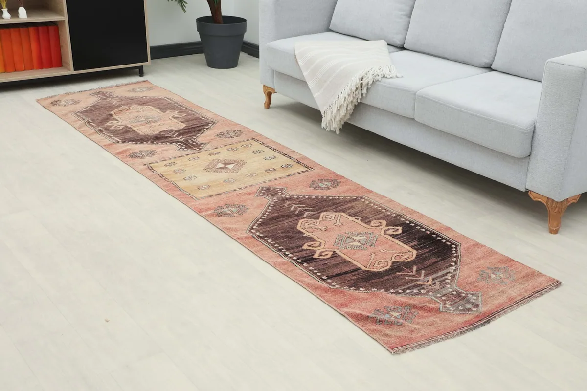 Angle view of the runner rug extending from the sofa, showing its length and colors in a room.