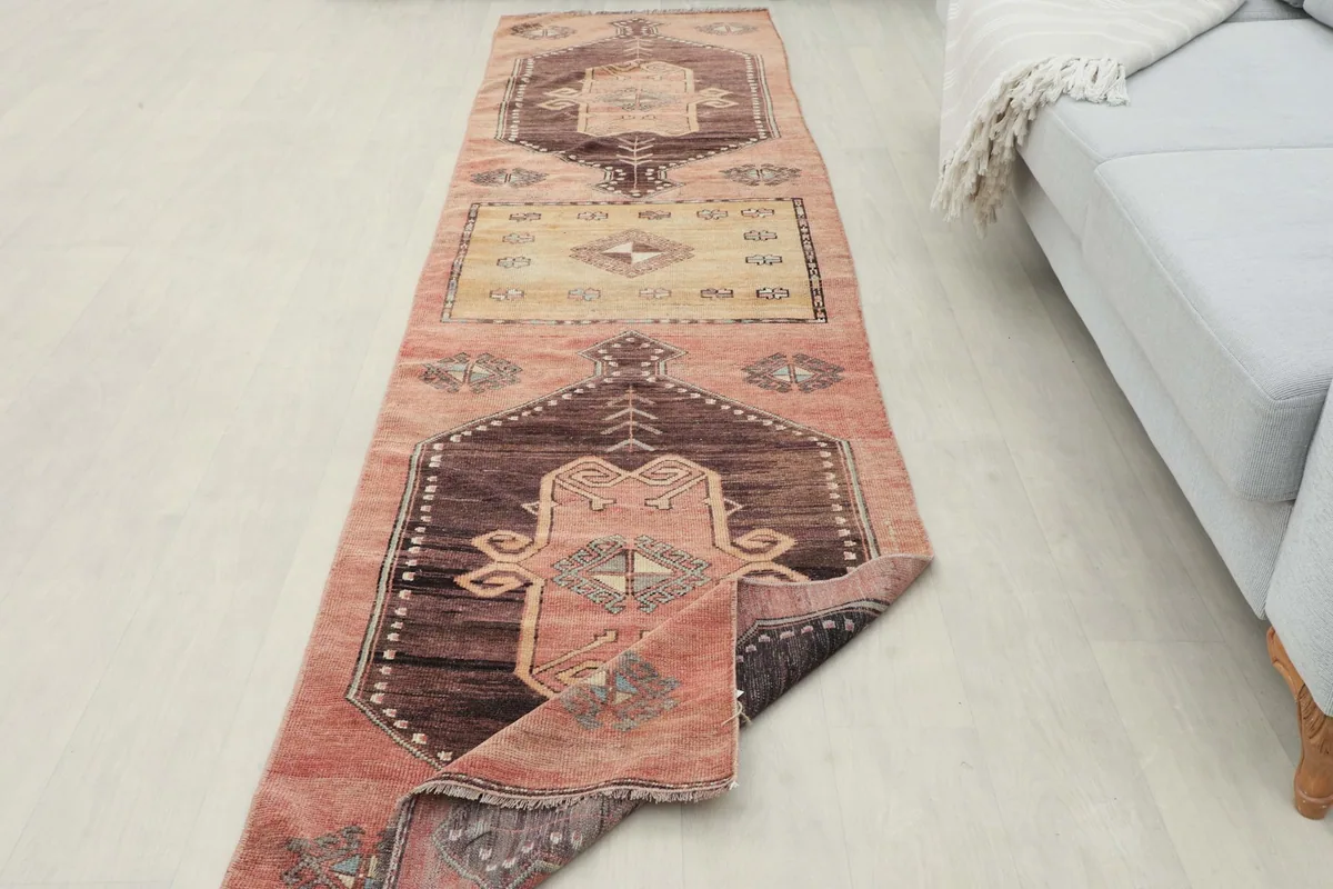 Overhead view of the runner rug partially unrolled in a room setting, showing its full design.