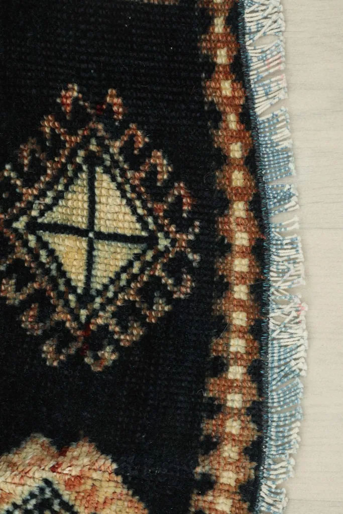 Close-up of the rug's short fringe and the edge, with visible hand-knotted details.