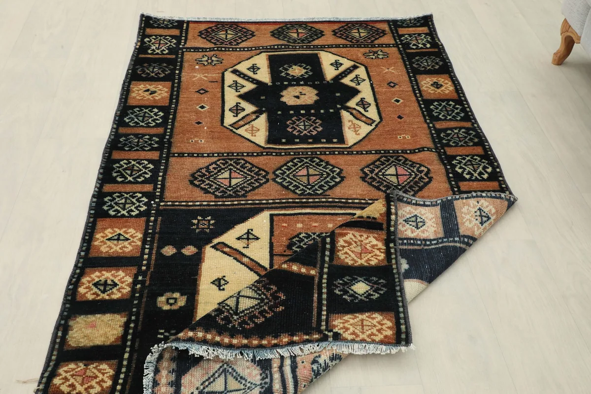 The rug partially folded, showing the reverse side and the hand-knotted construction.
