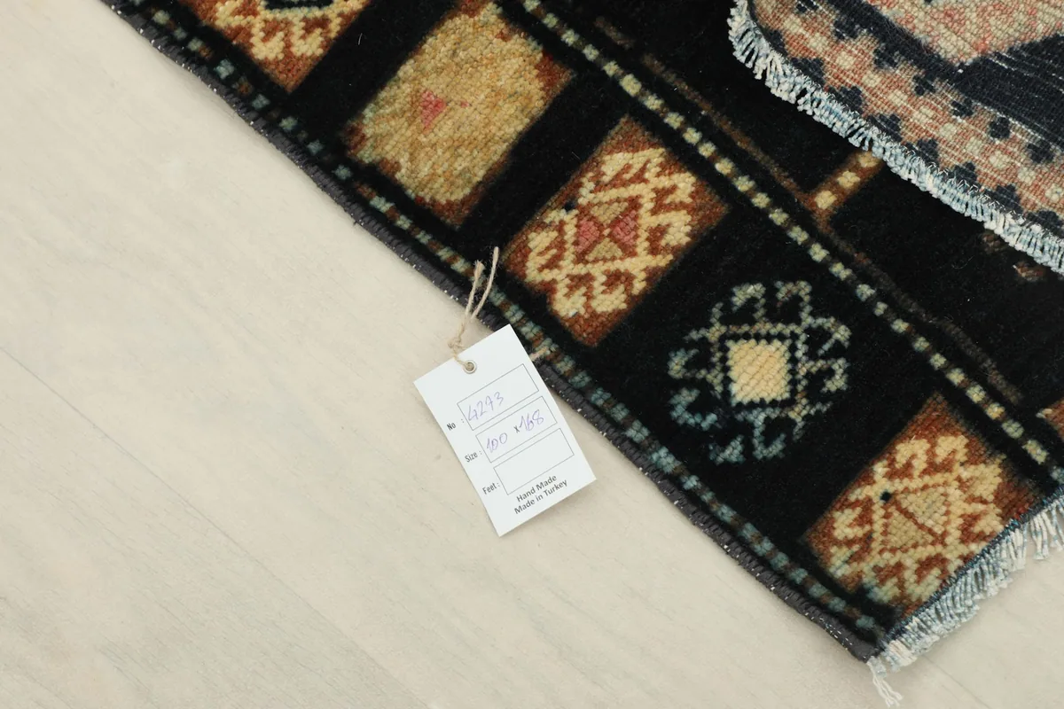 Corner of the rug with the product tag attached, showing the hand-knotted quality.