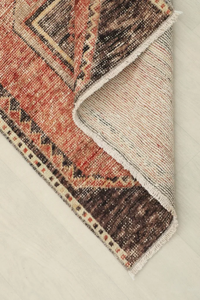 View of the rug's reverse side and pile, demonstrating the hand-knotted construction on a cotton foundation.