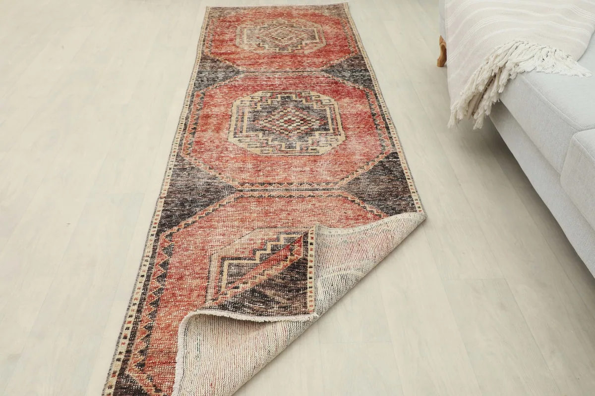 Rug partially folded, displaying its flexibility and the texture of the reverse side and pile.