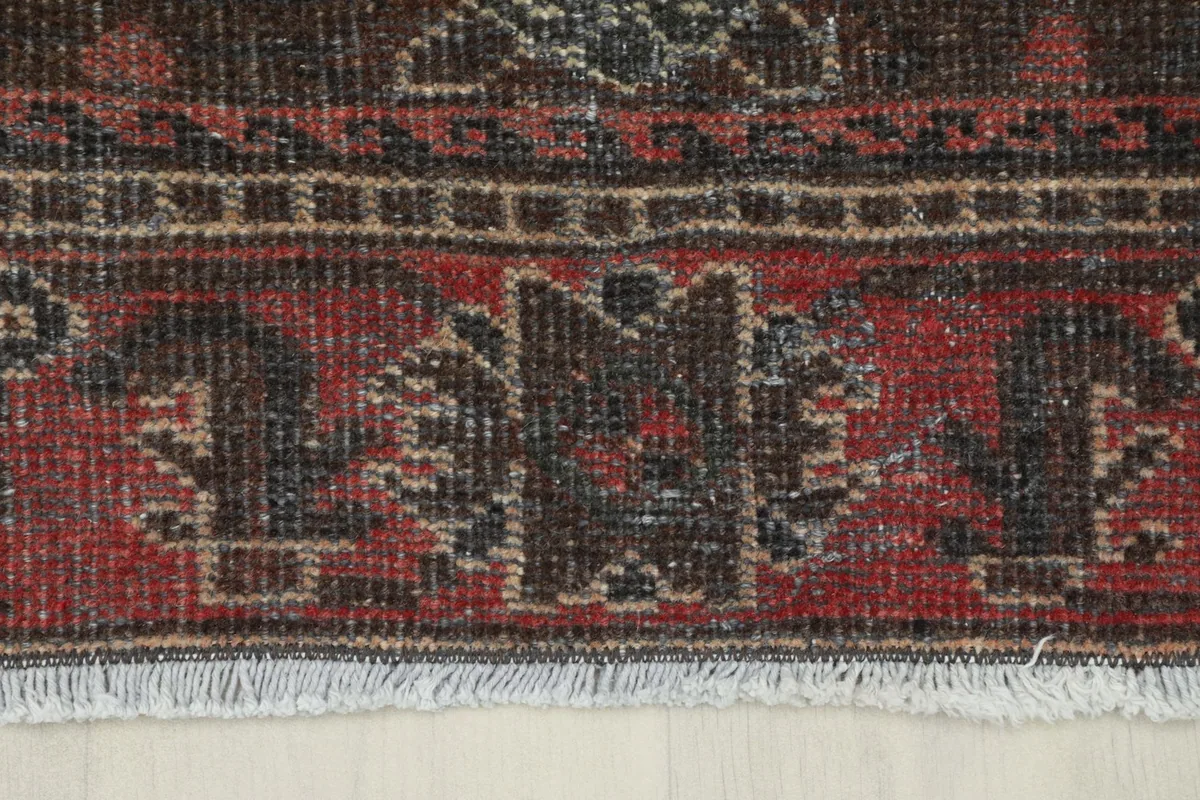 Detailed view of the red border and fringe, showcasing the intricate tribal patterns.