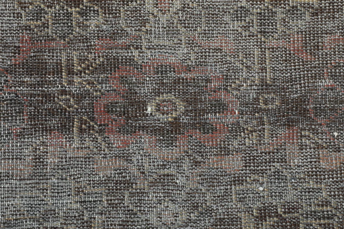 Close-up of the low wool pile and hand-knotted texture, showing the subtle color variations and wear.