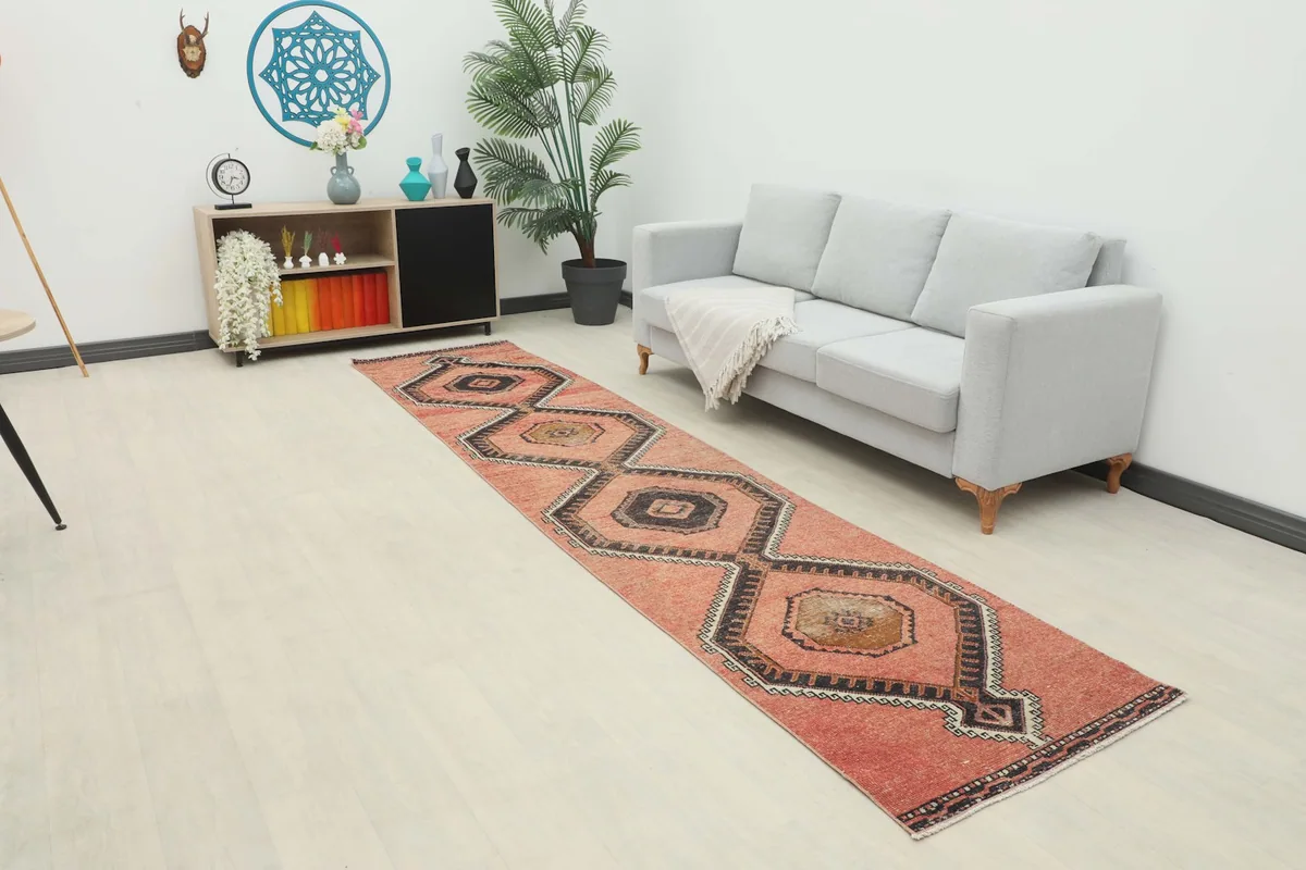 Wide view of the rust runner rug in a room setting with a light gray sofa