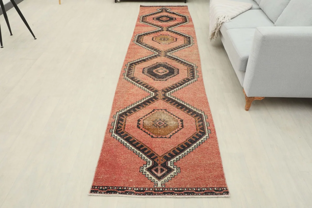 Full room view of the rust runner rug in front of a light gray sofa