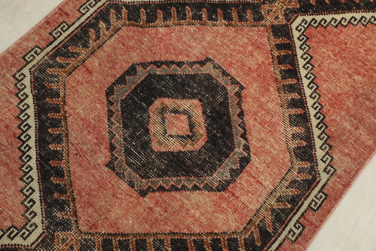 Detailed view of a black octagonal motif and surrounding beige and black border patterns