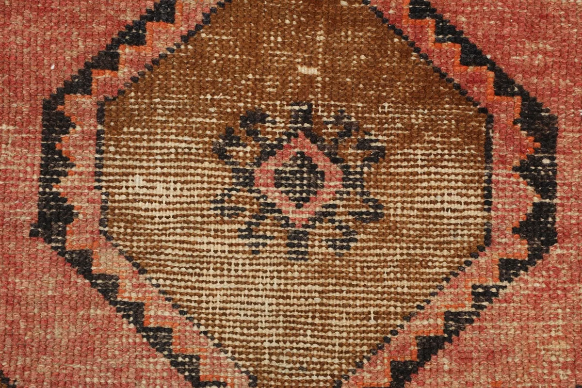 Close-up of a brown and rust central medallion with subtle wear and texture