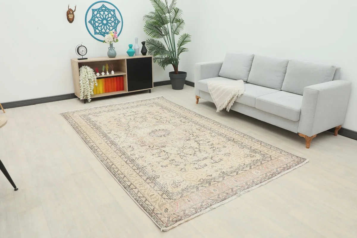 Beige vintage Anatolian rug displayed in a living room setting with a light gray couch.