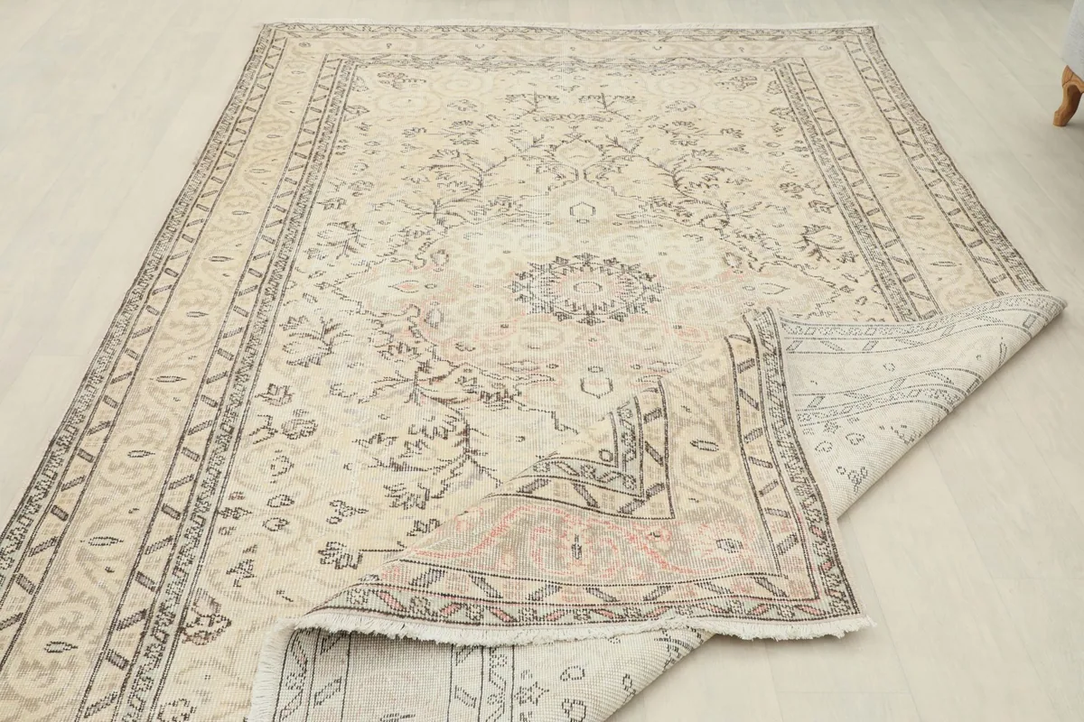 Rug partially folded, showing the flexibility and the underside of the hand-knotted wool pile.