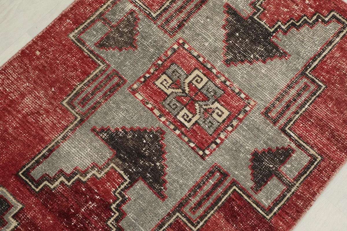 Detailed view of the central medallion-like geometric pattern with beige and red elements.