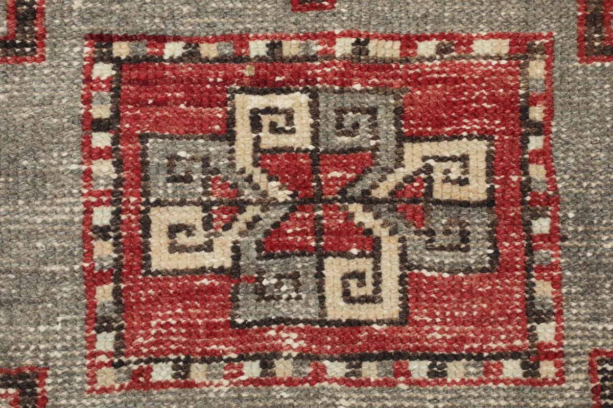 Macro detail of the intricate tribal design within a central gray pattern on the runner.