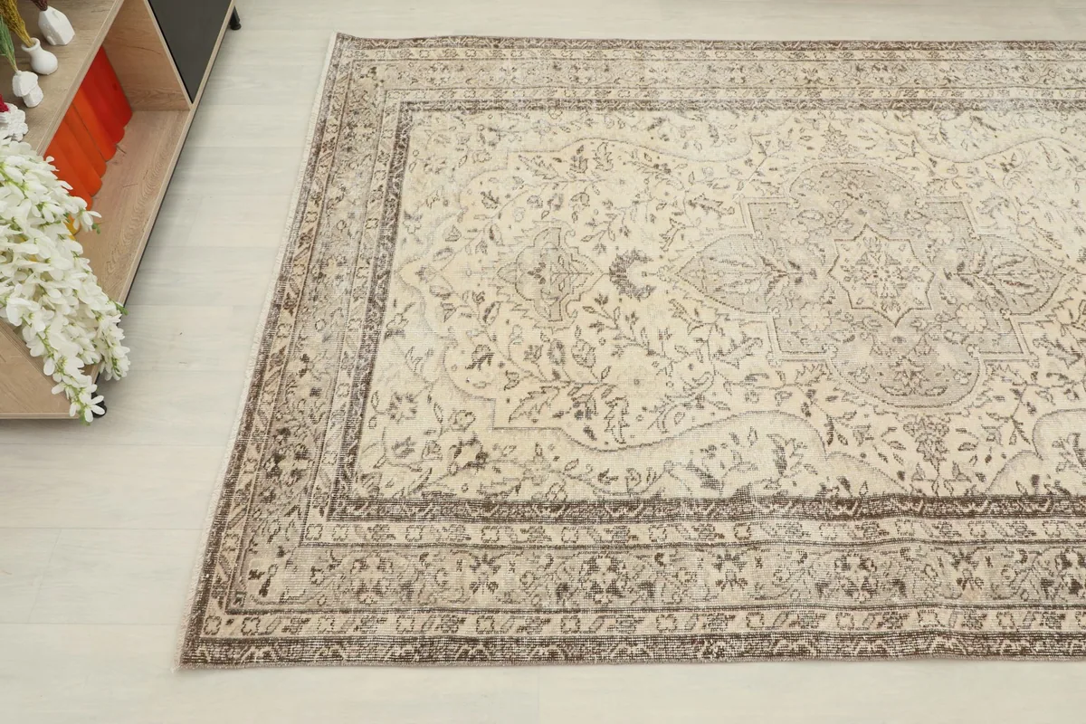 Angled shot of the rug's surface, showing the faded patterns and soft colors