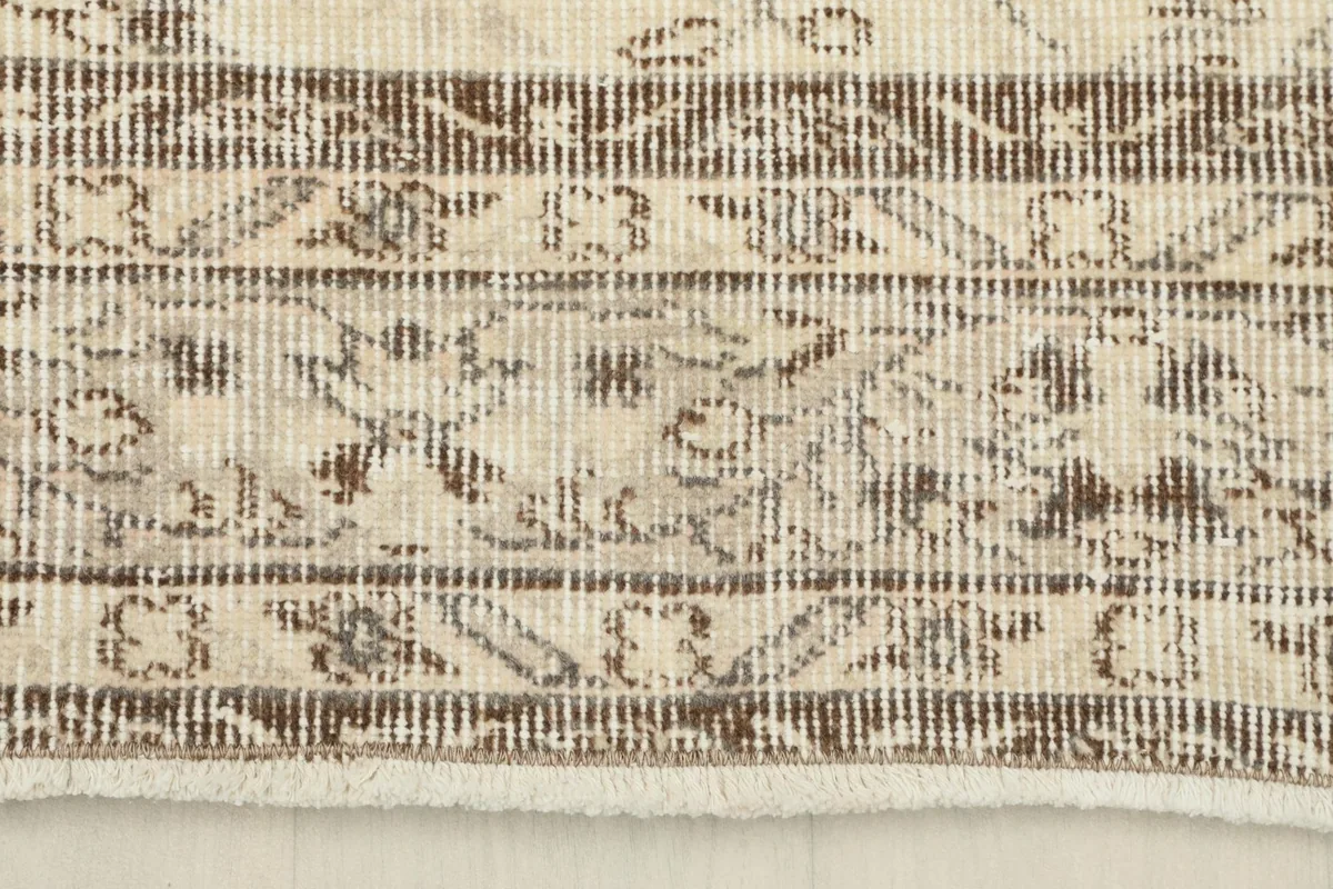 Close-up of the rug's border design and fringe, showing the wool pile
