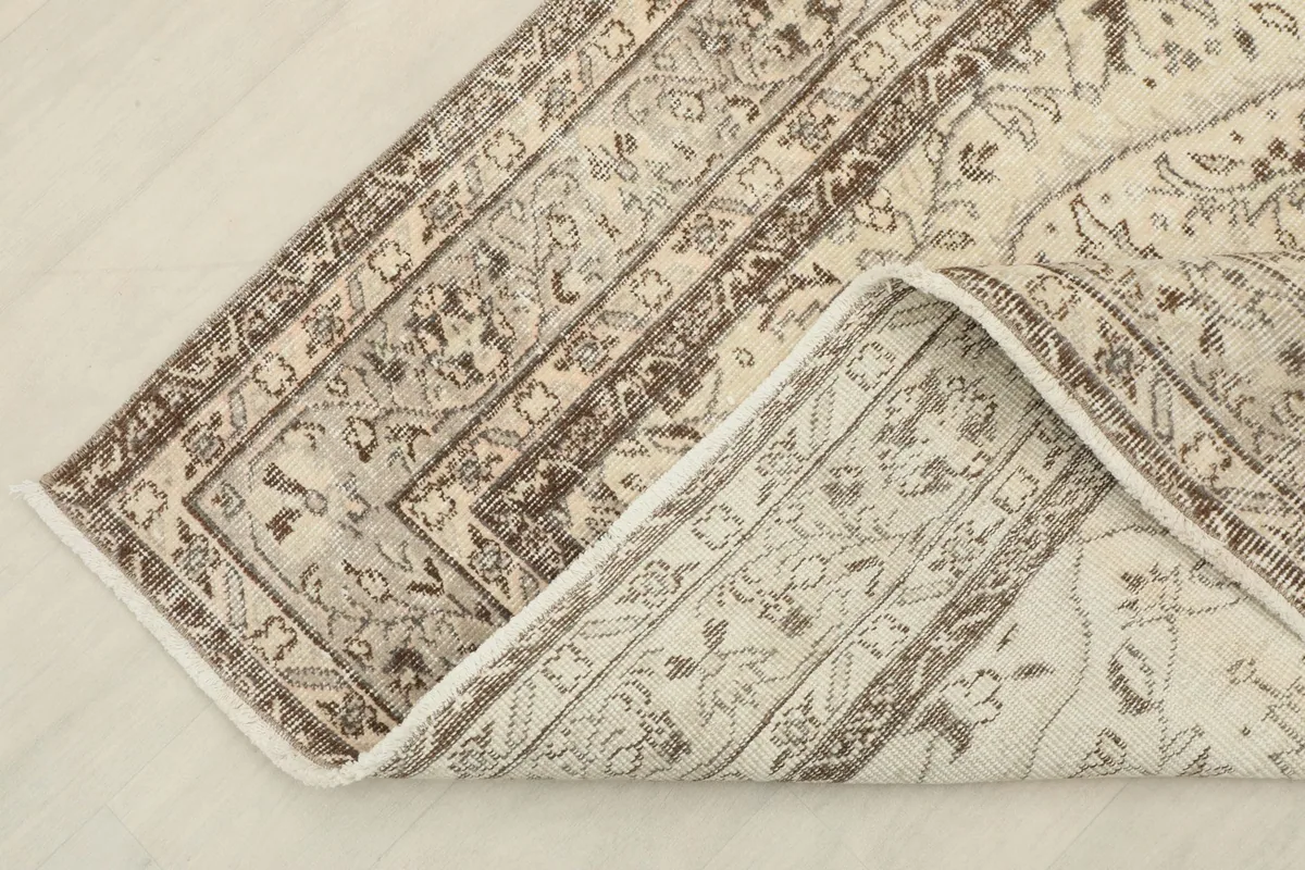 Close-up of the rug's corner folded back, revealing the cotton foundation