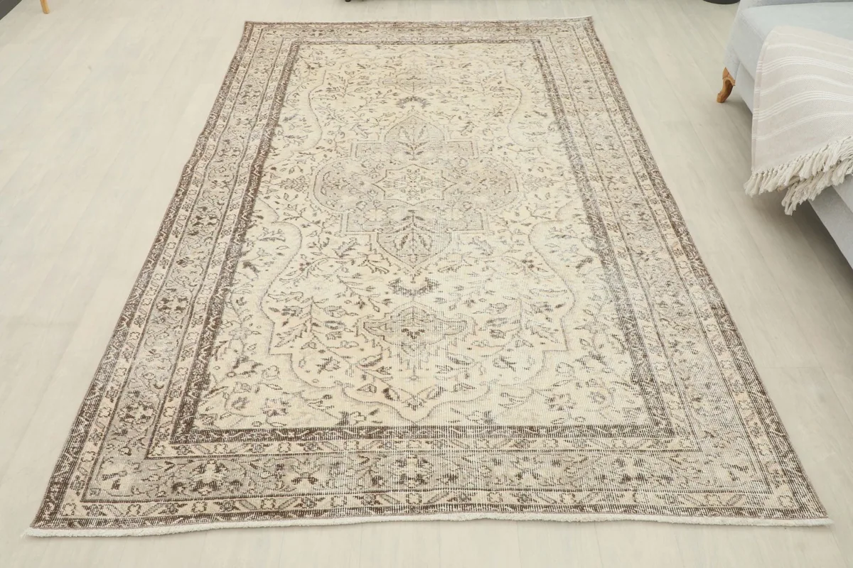 Full overhead view of the cream and gray vintage Anatolian rug on a light floor
