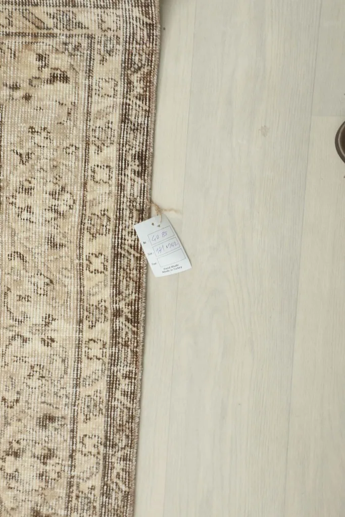 Partial view of the rug with a size tag, showing its natural color variation